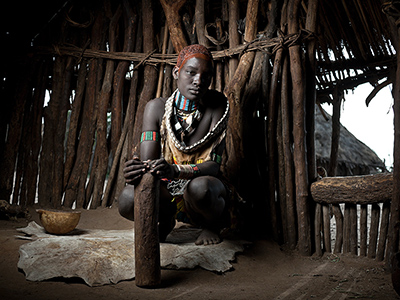 Young Hamar woman in traditional hut - Guillaume Petermann